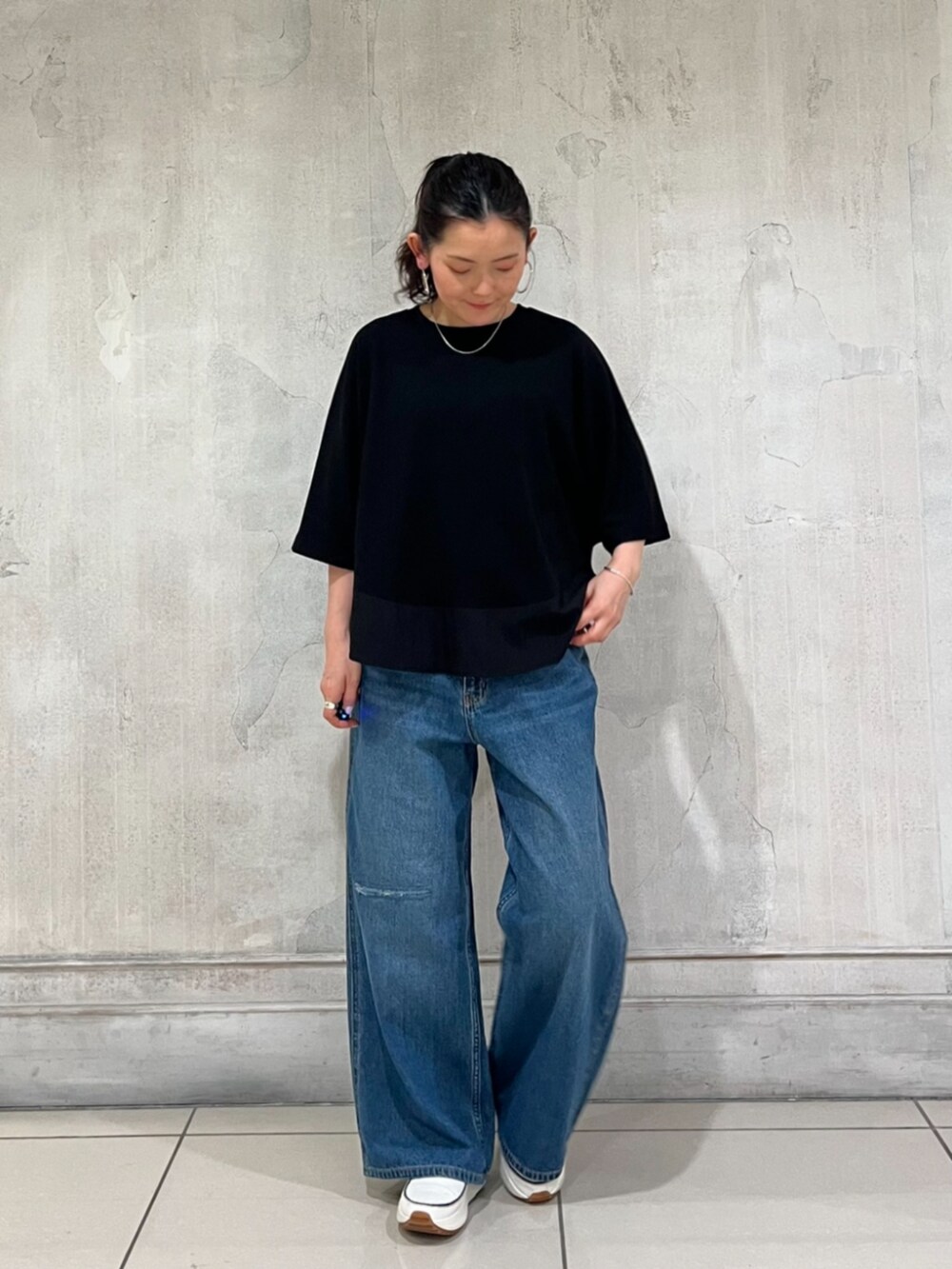 ブルー系のその他パンツ、ブラック系のTシャツ/カットソー、ホワイト系のスニーカーを着用したレディースの春コーディネートの5枚目の写真
