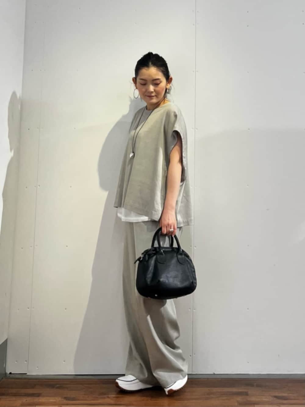 ホワイト系のスニーカー、グレー系のシャツ/ブラウス、ブラック系のボストンバッグを着用したレディースの春コーディネートの2枚目の写真