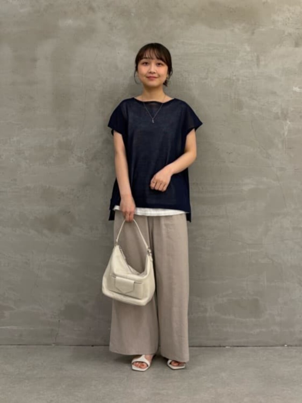 ホワイト系のトートバッグ、グレー系のその他パンツ、ブルー系のニット/セーターを着用したレディースの春コーディネートの3枚目の写真