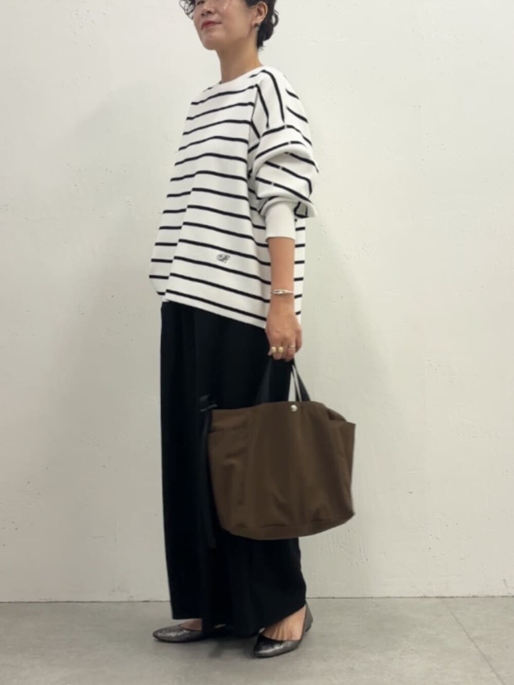 ホワイト系のノーカラージャケット、ブラック系のその他パンツ、ホワイト系のニット/セーターを着用したレディースの冬コーディネートの5枚目の写真