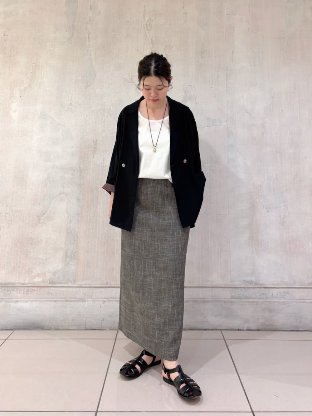 ブラック系のテーラードジャケット、ホワイト系のシャツ/ブラウス、ベージュ系のスカートを着用したレディースの春コーディネートの3枚目の写真
