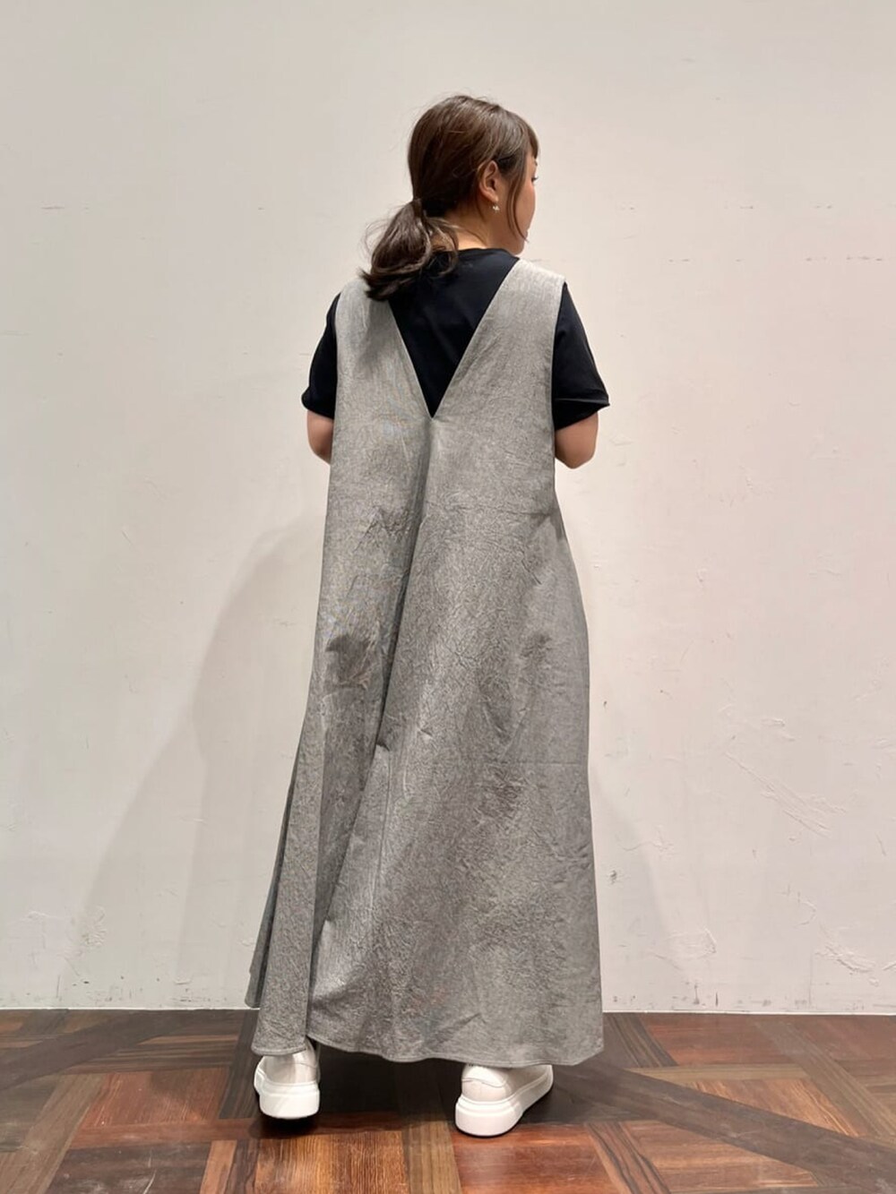 グレー系のワンピース、ブラック系のTシャツ/カットソー、ホワイト系のトートバッグを着用したレディースの春コーディネートの3枚目の写真