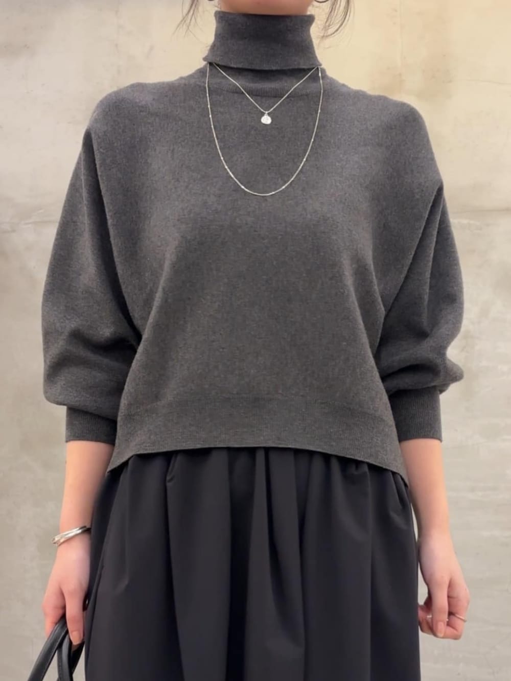 グレー系のニット/セーター、ブラック系のスカートを着用したレディースの冬コーディネートの7枚目の写真