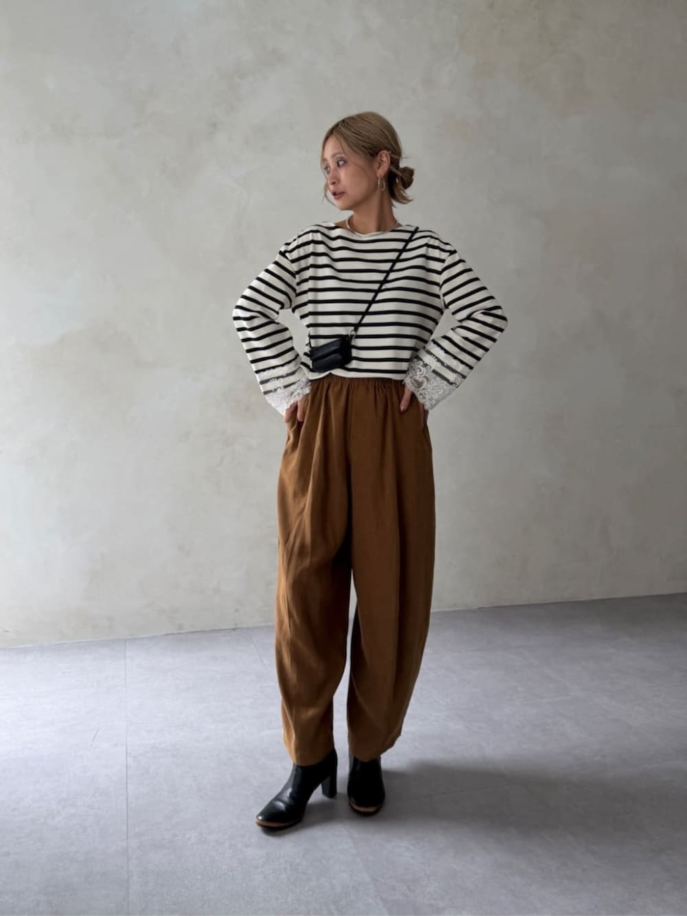 ホワイト系のTシャツ/カットソー、イエロー系のその他パンツ、ブラック系のポーチを着用したレディースの夏コーディネートの2枚目の写真