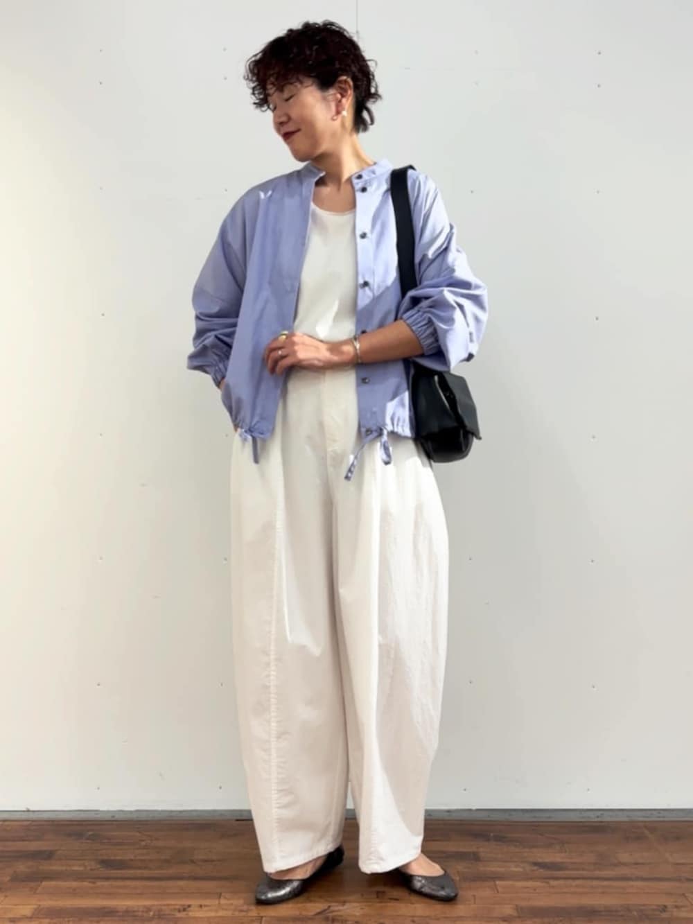 ホワイト系のタンクトップ、ブラック系のショルダーバッグ、ホワイト系のその他パンツを着用したレディースの冬コーディネートの2枚目の写真