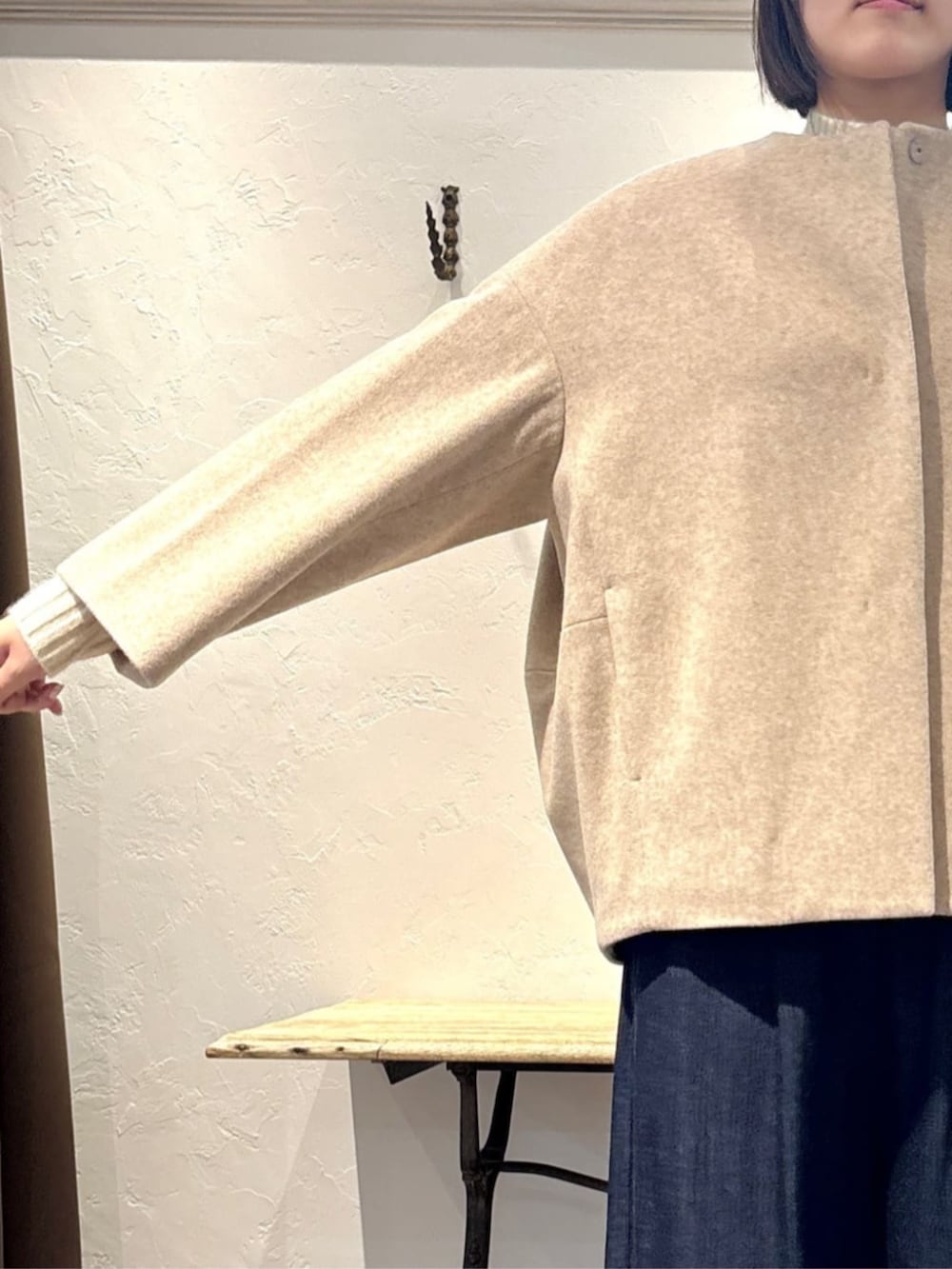 ブルー系のその他パンツ、グリーン系のハンドバッグ、ホワイト系のニット/セーターを着用したレディースの冬コーディネートの5枚目の写真