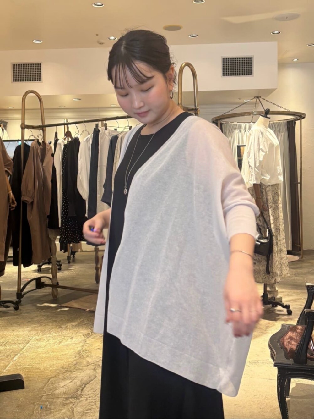 ブラック系のワンピース、グレー系のカーディガン/ボレロを着用したレディースの春コーディネートの8枚目の写真