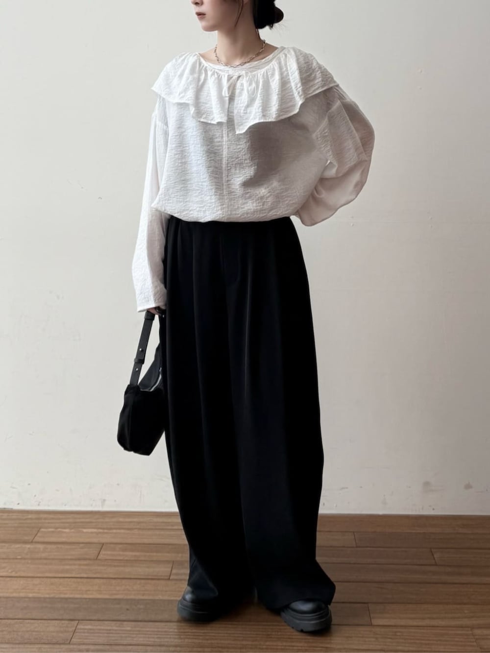 ブラック系のショルダーバッグ、ブラック系のその他パンツ、ホワイト系のシャツ/ブラウスを着用したレディースの冬コーディネートの2枚目の写真