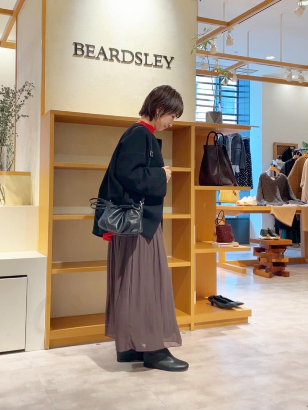 ブラウン系のその他パンツ、ブラック系のノーカラーコート、ブラック系のブーツを着用したレディースの冬コーディネートの5枚目の写真