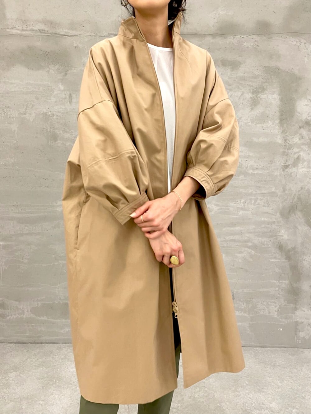 イエロー系のノーカラーコート、ホワイト系のシャツ/ブラウス、グリーン系のその他パンツを着用したレディースの春コーディネートの2枚目の写真