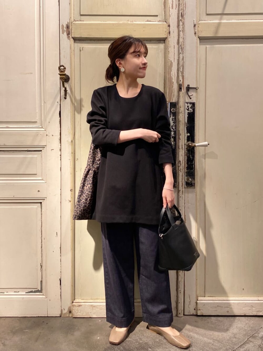 ブラック系のシャツ/ブラウス、ブルー系のデニムパンツ、ブラック系のショルダーバッグを着用したレディースの秋コーディネートの3枚目の写真