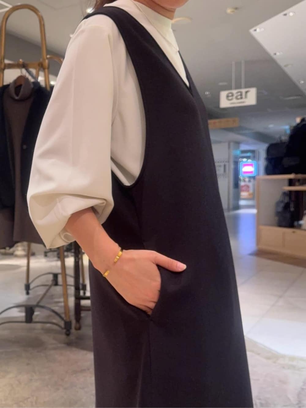 ホワイト系のシャツ/ブラウス、ブラック系のブーツ、ブラック系のジャンパースカートを着用したレディースの冬コーディネートの5枚目の写真