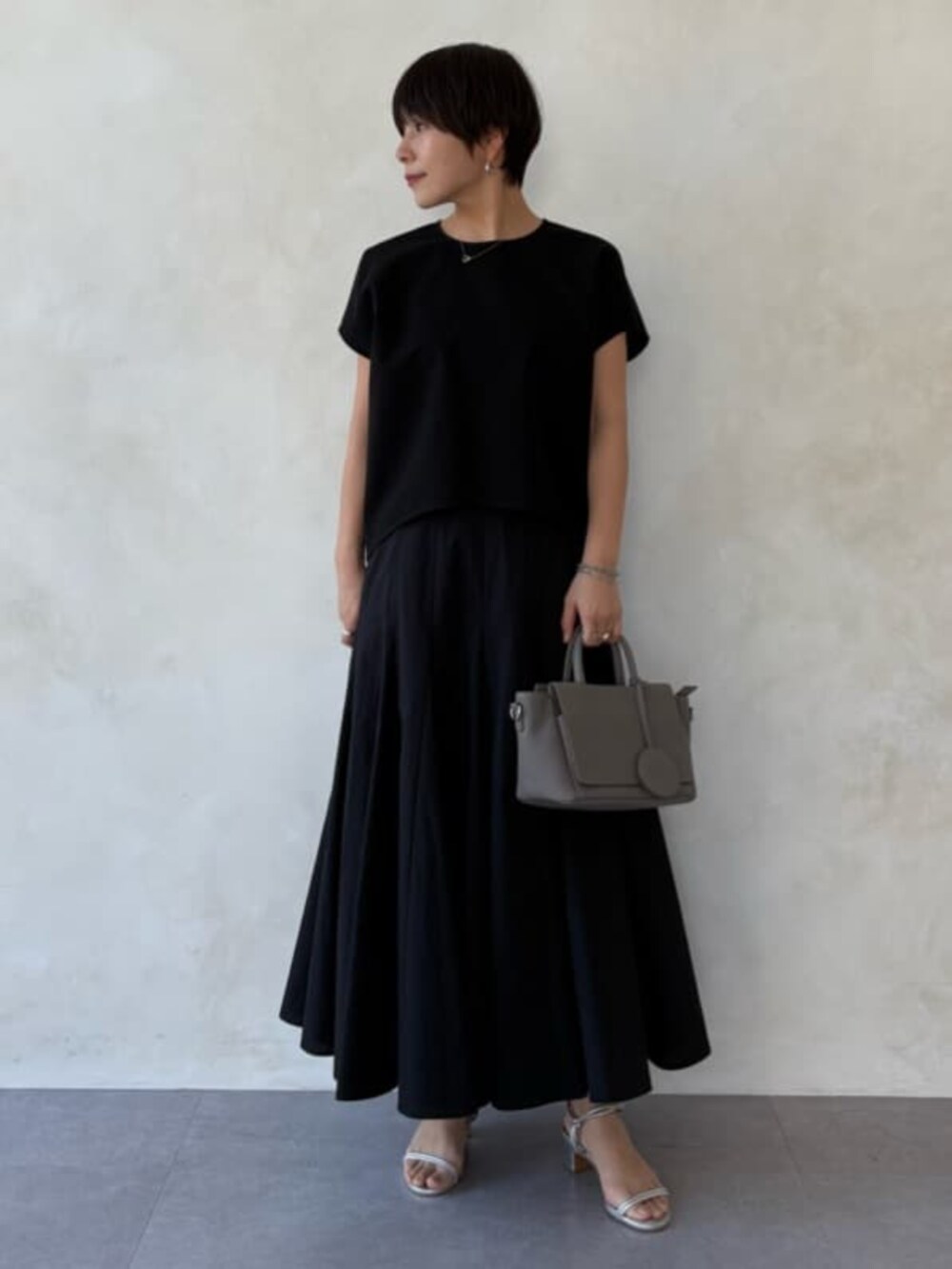 グレー系のハンドバッグ、ブラック系のシャツ/ブラウス、ブラック系のスカートを着用したレディースの春コーディネートの4枚目の写真