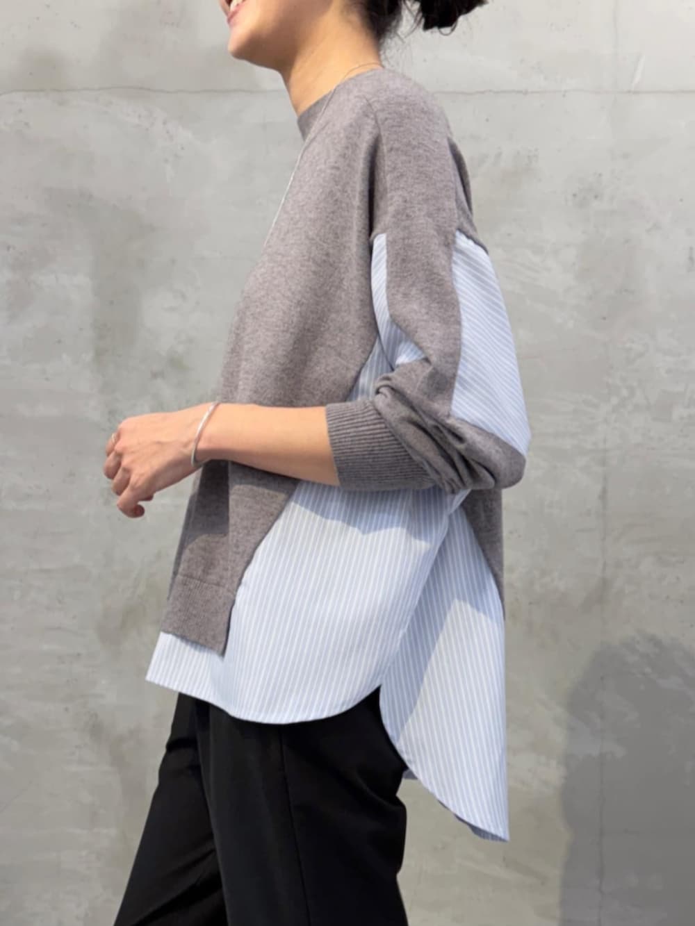 グレー系のニット/セーター、ブラック系のその他パンツ、ブラック系のローファーを着用したレディースの秋コーディネートの6枚目の写真