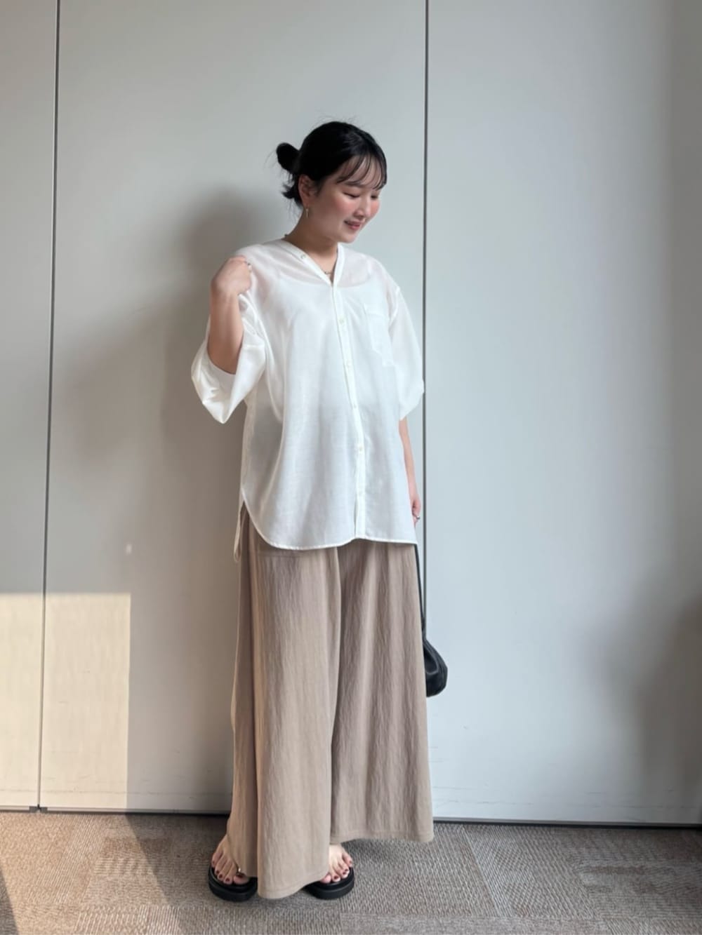 ベージュ系のその他パンツ、ブラック系のサンダル、ホワイト系のシャツ/ブラウスを着用したレディースの冬コーディネートの2枚目の写真