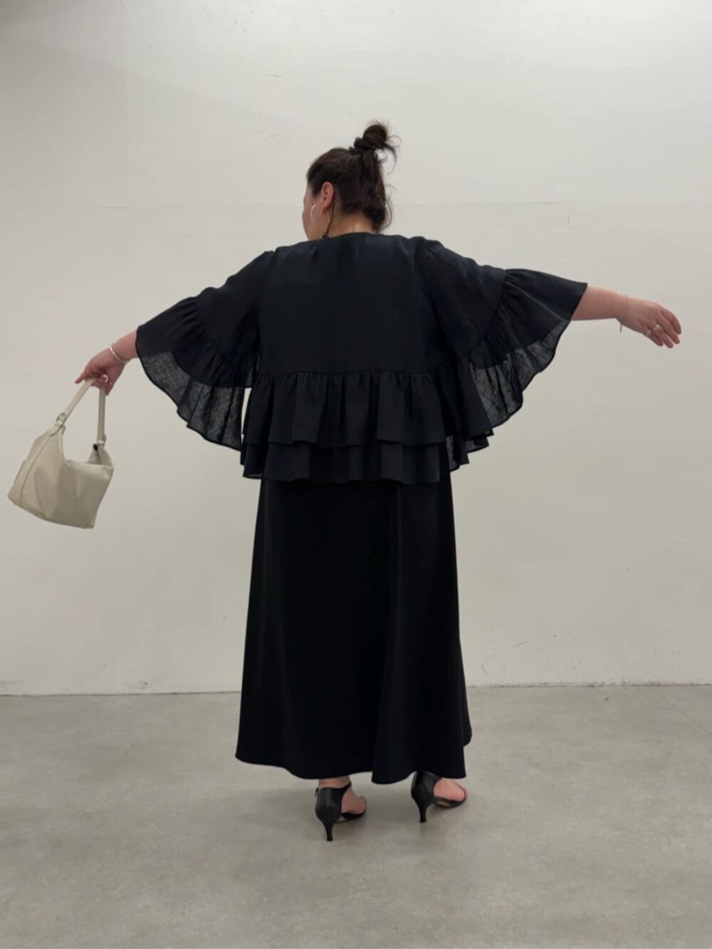 ブラック系のワンピース、ブラック系のその他アウターを着用したレディースの春コーディネートの6枚目の写真