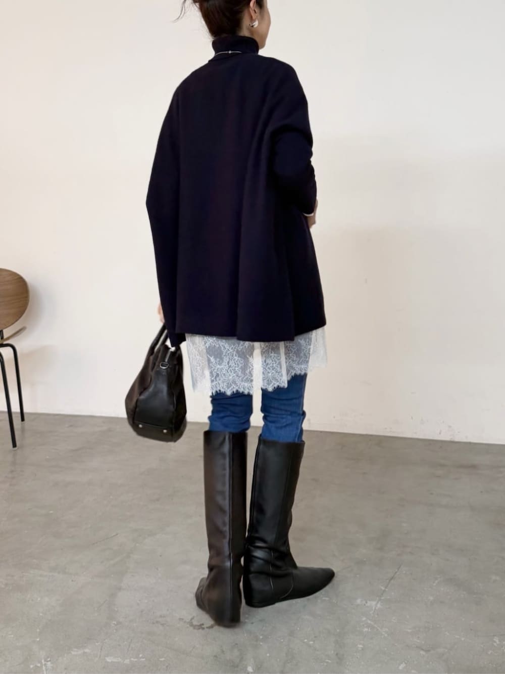 ブルー系のデニムパンツ、ブラック系のトートバッグ、ホワイト系のTシャツ/カットソーを着用したレディースの秋コーディネートの6枚目の写真