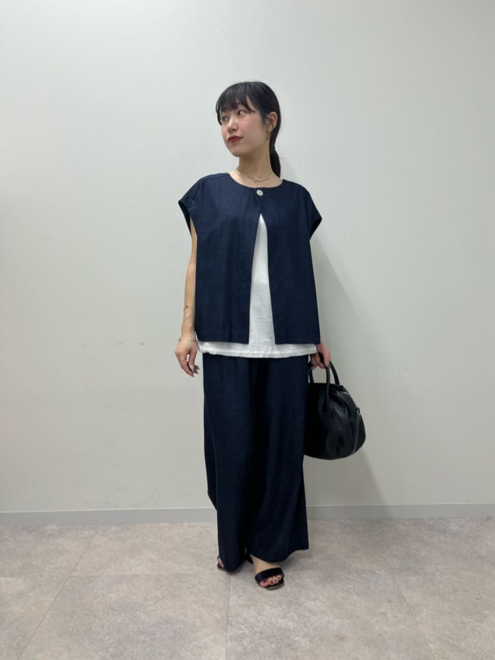 ブルー系のシャツ/ブラウス、ブルー系のその他パンツ、ブラック系のボストンバッグを着用したレディースの春コーディネートの4枚目の写真