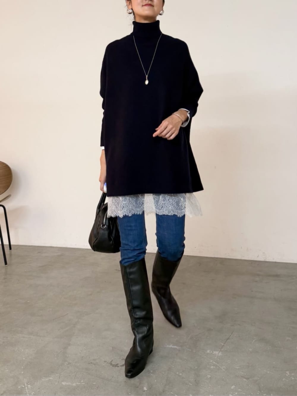 ブルー系のデニムパンツ、ブラック系のトートバッグ、ホワイト系のTシャツ/カットソーを着用したレディースの秋コーディネートの4枚目の写真