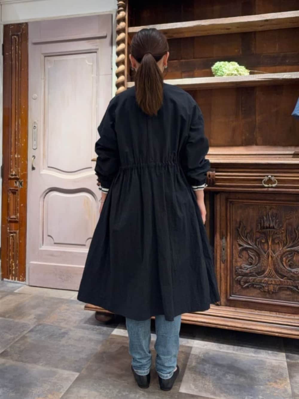 ブラック系のその他アウター、ブルー系のデニムパンツ、ブルー系のTシャツ/カットソーを着用したレディースの冬コーディネートの3枚目の写真