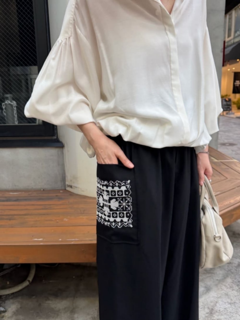 ホワイト系のシャツ/ブラウス、ブラック系のその他パンツ、ブラック系のブーツを着用したレディースの秋コーディネートの10枚目の写真