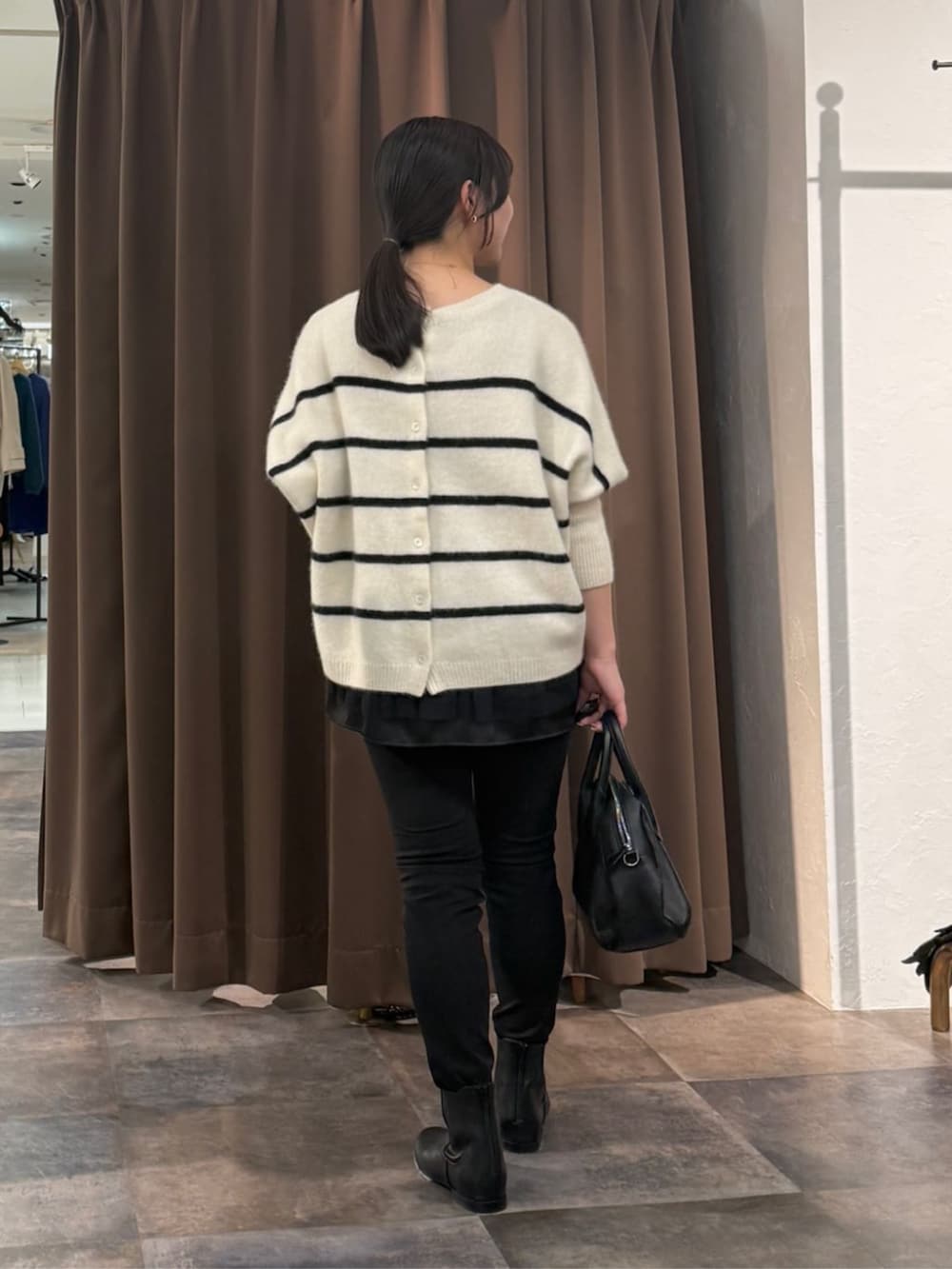 ブラック系のその他パンツ、ホワイト系のニット/セーター、ブラック系のタンクトップを着用したレディースの冬コーディネートの3枚目の写真