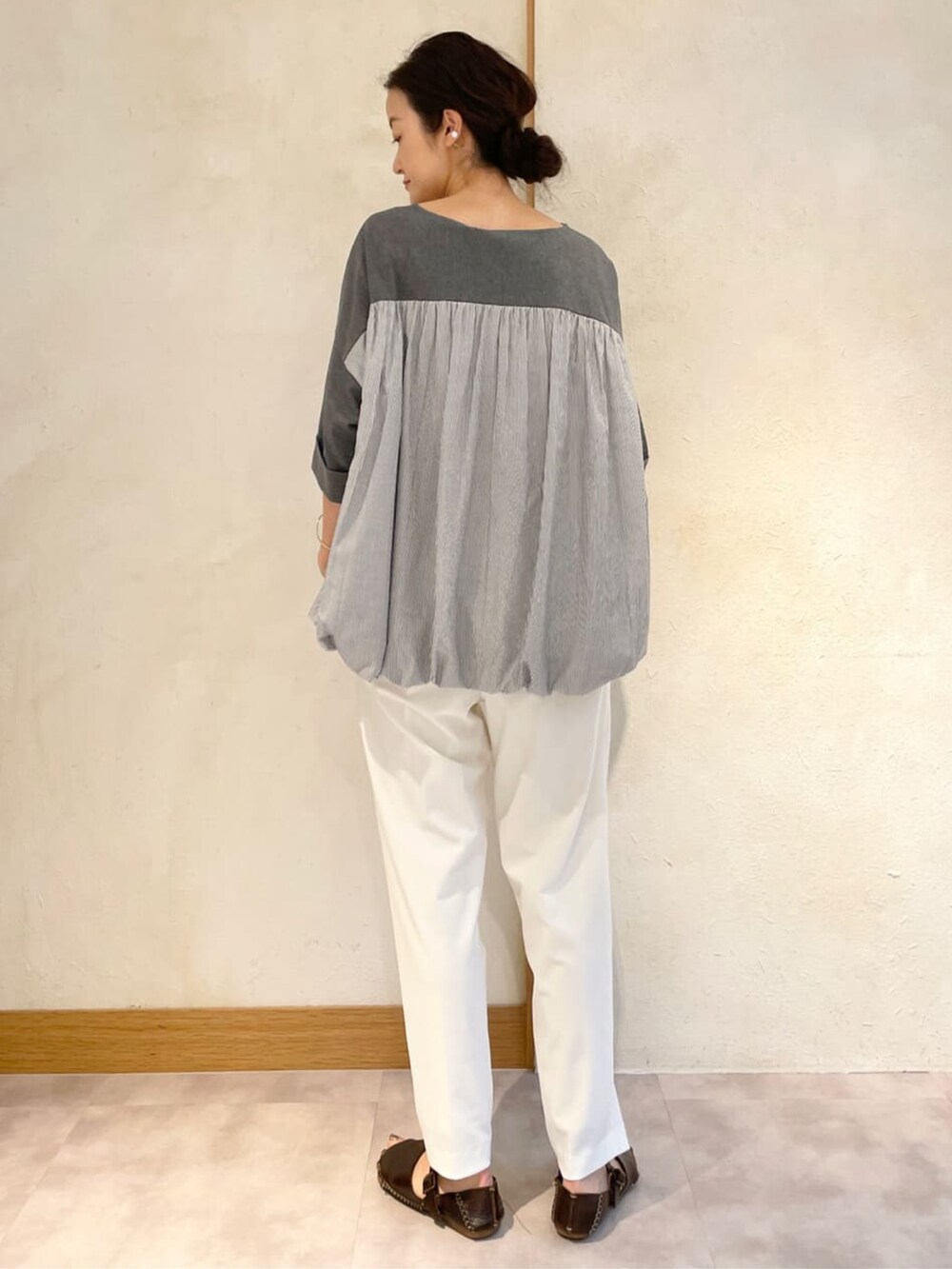 グレー系のTシャツ/カットソー、ホワイト系のその他パンツ、ブラウン系のサンダルを着用したレディースの夏コーディネートの2枚目の写真