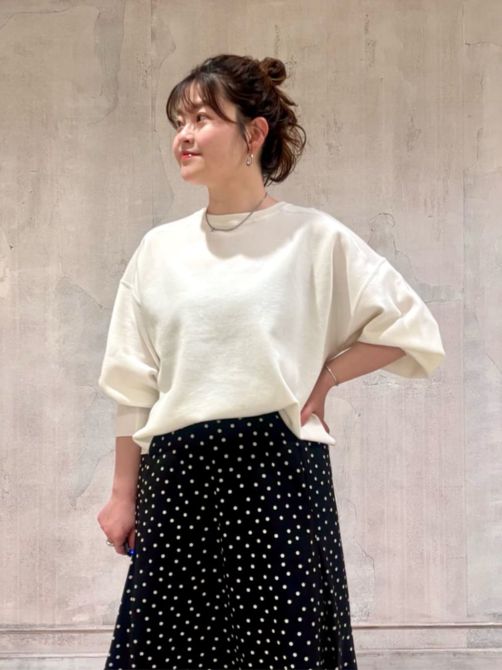 ブラック系のハンドバッグ、ブラック系のスカート、ホワイト系のTシャツ/カットソーを着用したレディースの春コーディネートの5枚目の写真