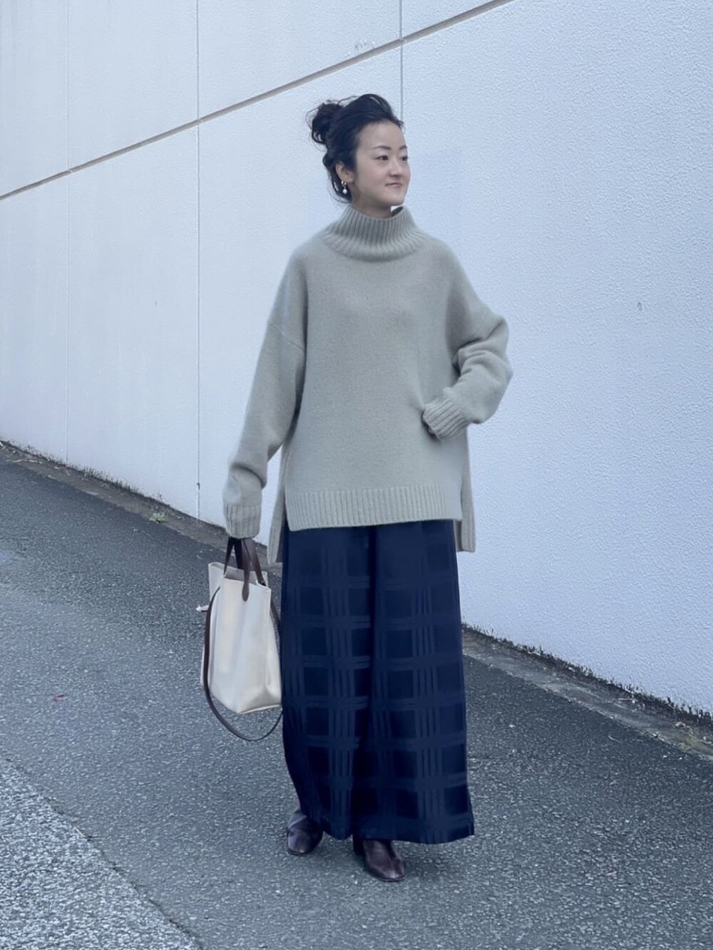 ブルー系のその他パンツ、グリーン系のニット/セーター、ベージュ系のショルダーバッグを着用したレディースの秋コーディネートの3枚目の写真