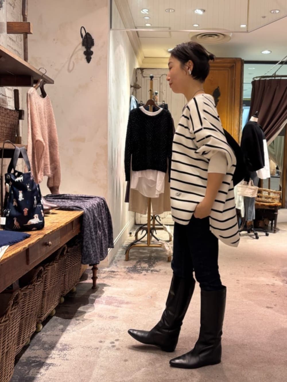 ブルー系のデニムパンツ、ホワイト系のニット/セーター、ブラック系のショルダーバッグを着用したレディースの冬コーディネートの2枚目の写真