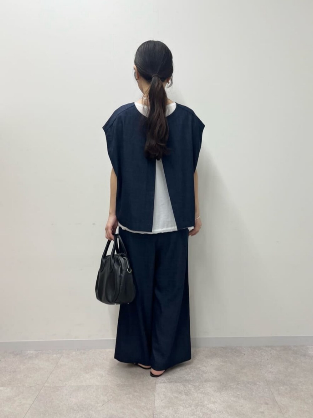 ブルー系のシャツ/ブラウス、ブルー系のその他パンツ、ブラック系のボストンバッグを着用したレディースの春コーディネートの7枚目の写真
