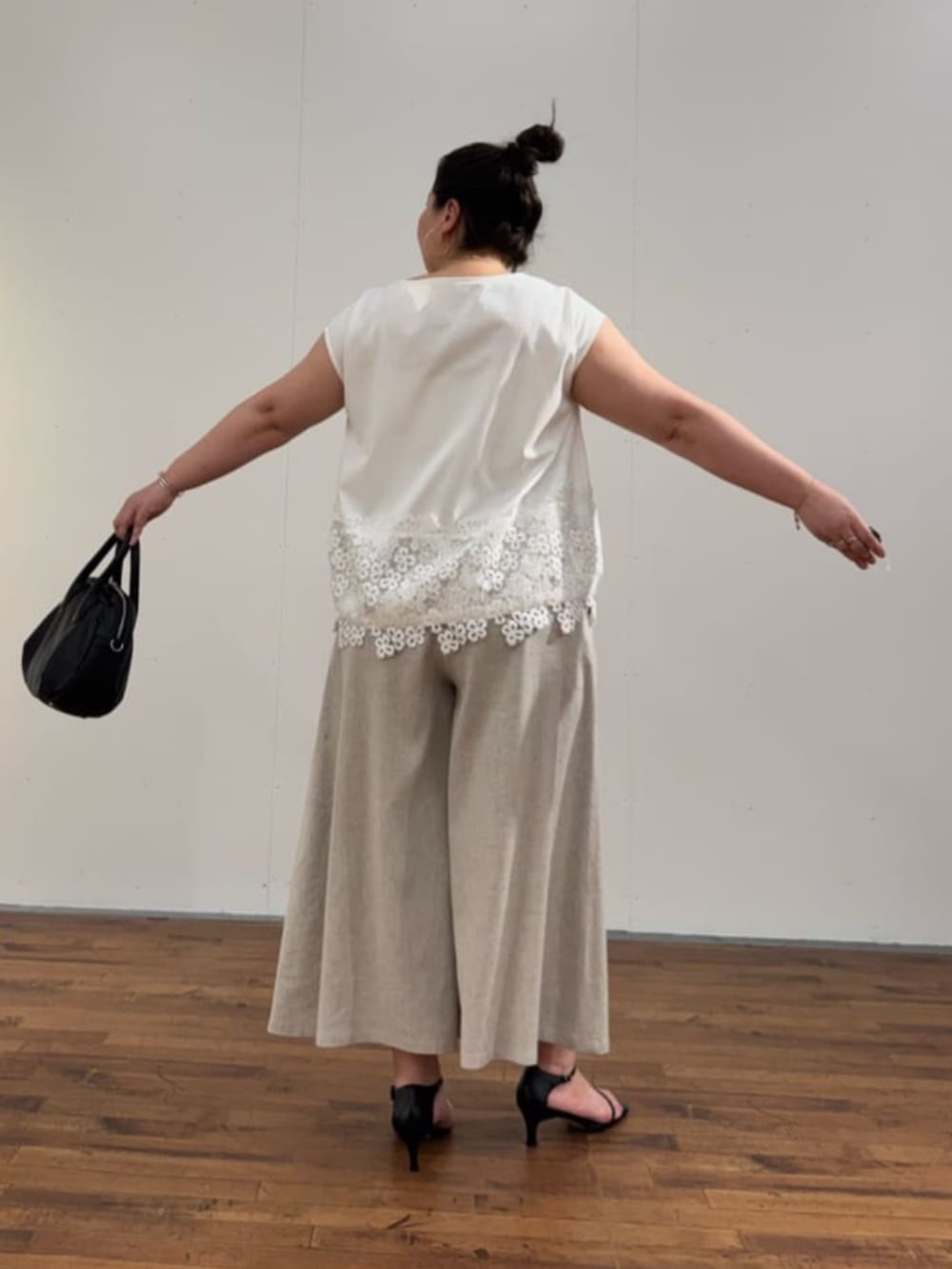 ブラック系のボストンバッグ、ホワイト系のTシャツ/カットソー、ベージュ系のその他パンツを着用したレディースの春コーディネートの7枚目の写真