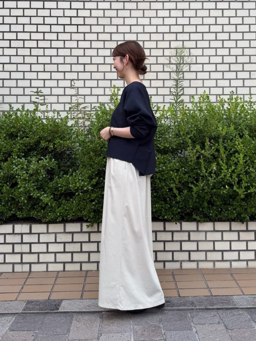 ベージュ系のスカート、ブルー系のカーディガン/ボレロ、シルバー系のトートバッグを着用したレディースの夏コーディネートの2枚目の写真
