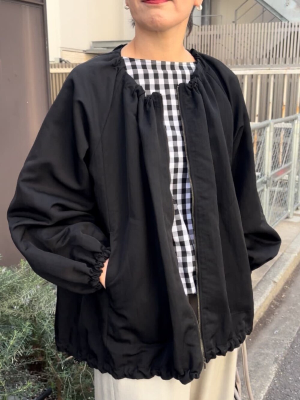 グレー系のボストンバッグ、ブラック系のノーカラージャケット、ブラック系のシャツ/ブラウスを着用したレディースの春コーディネートの5枚目の写真
