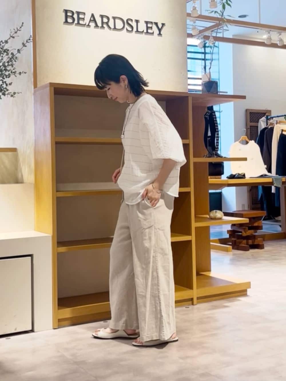 ベージュ系のその他パンツ、ホワイト系のシャツ/ブラウスを着用したレディースの春コーディネートの2枚目の写真