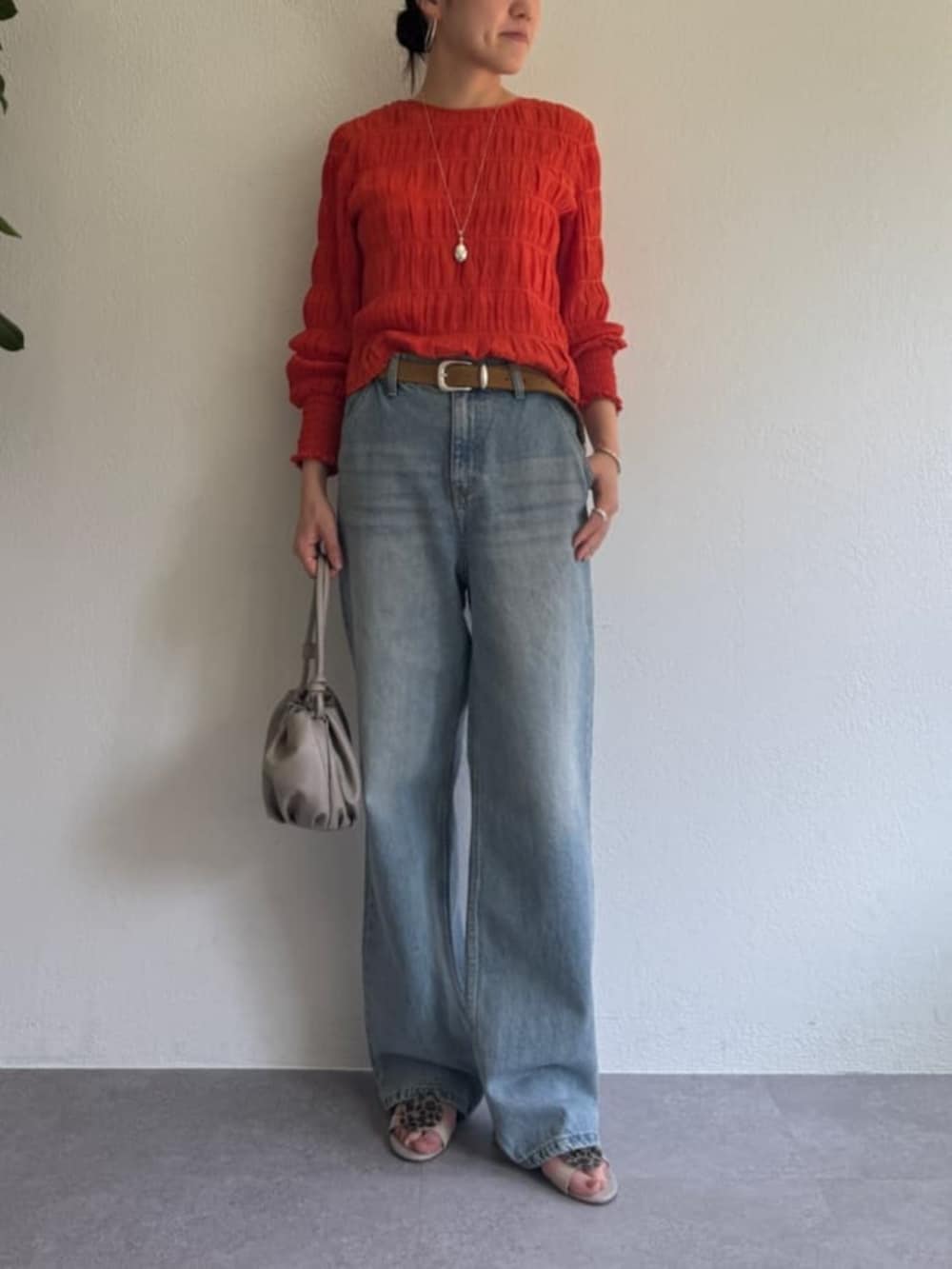 オレンジ系のシャツ/ブラウスを着用したレディースの春コーディネートの3枚目の写真