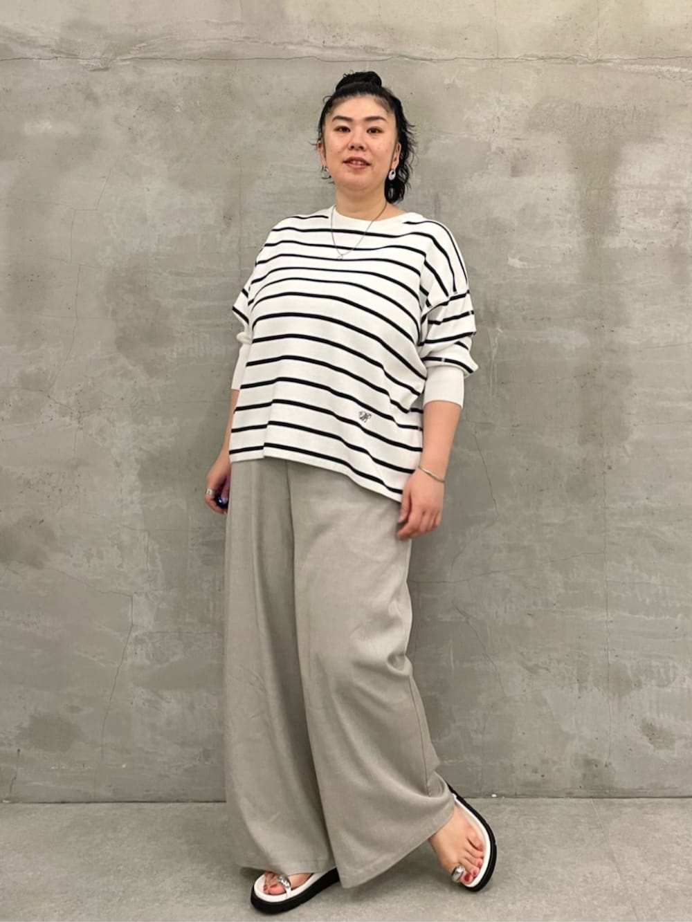 ブラック系のショルダーバッグ、ホワイト系のニット/セーター、ホワイト系のサンダルを着用したレディースの冬コーディネートの3枚目の写真