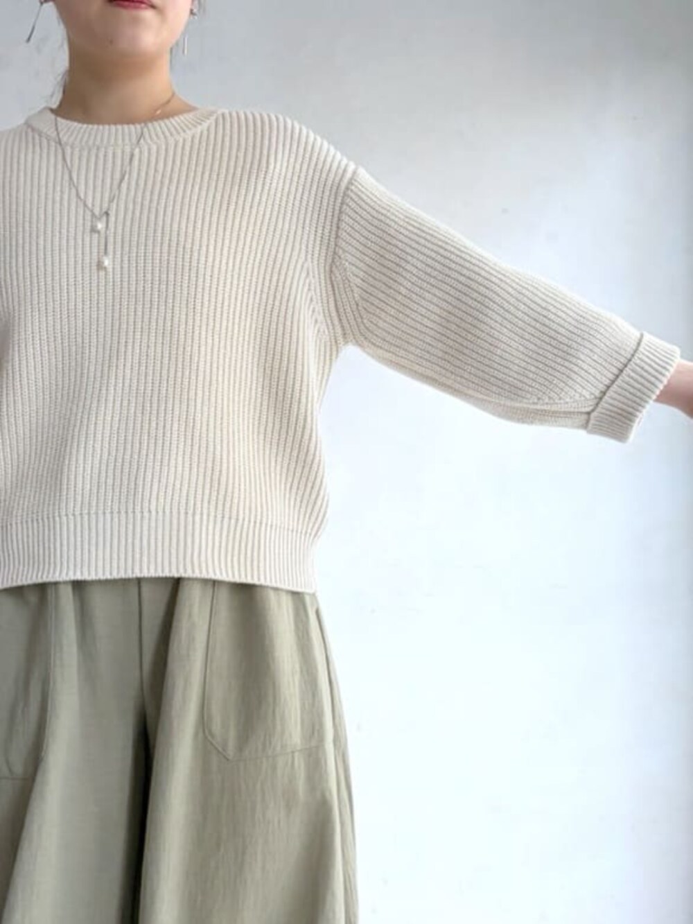 ホワイト系のニット/セーター、グリーン系のその他パンツ、ブラック系のトートバッグを着用したレディースの冬コーディネートの5枚目の写真