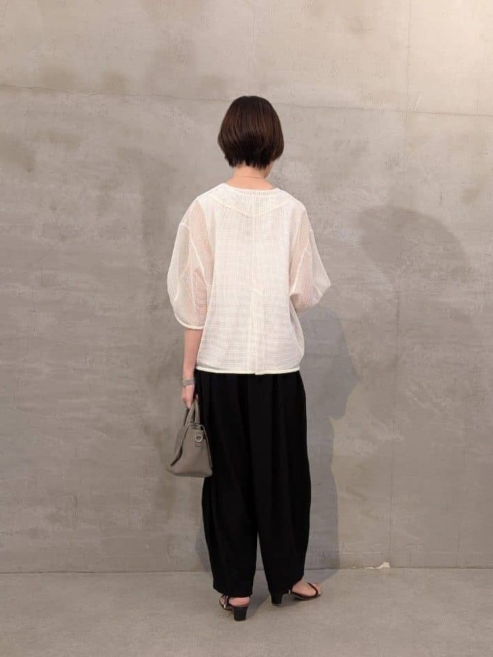 ブラック系のその他パンツ、ホワイト系のシャツ/ブラウスを着用したレディースの春コーディネートの3枚目の写真