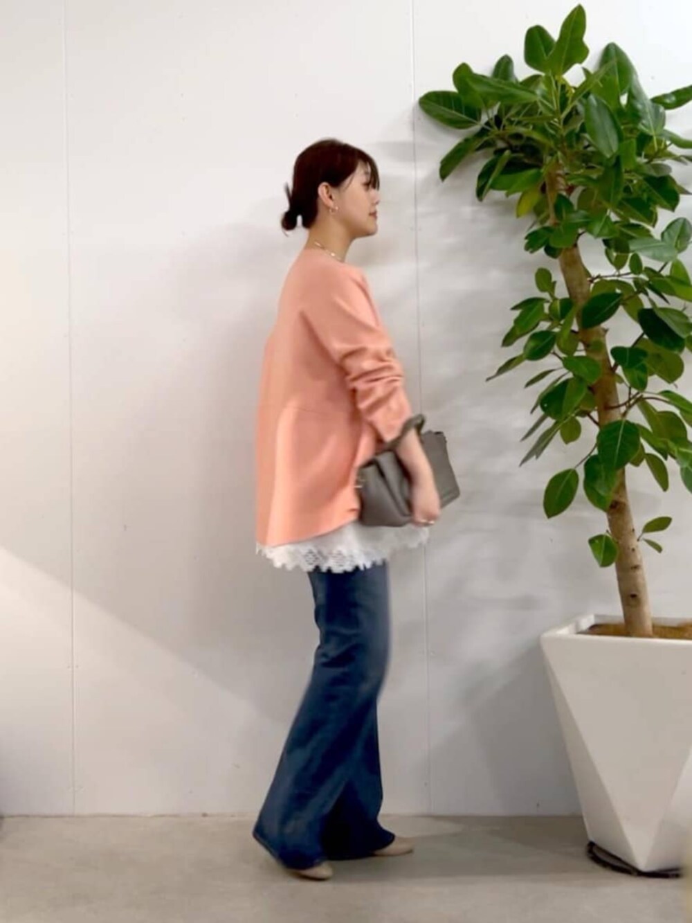 グレー系のハンドバッグ、ピンク系のニット/セーター、ホワイト系のキャミソールを着用したレディースの秋コーディネートの7枚目の写真