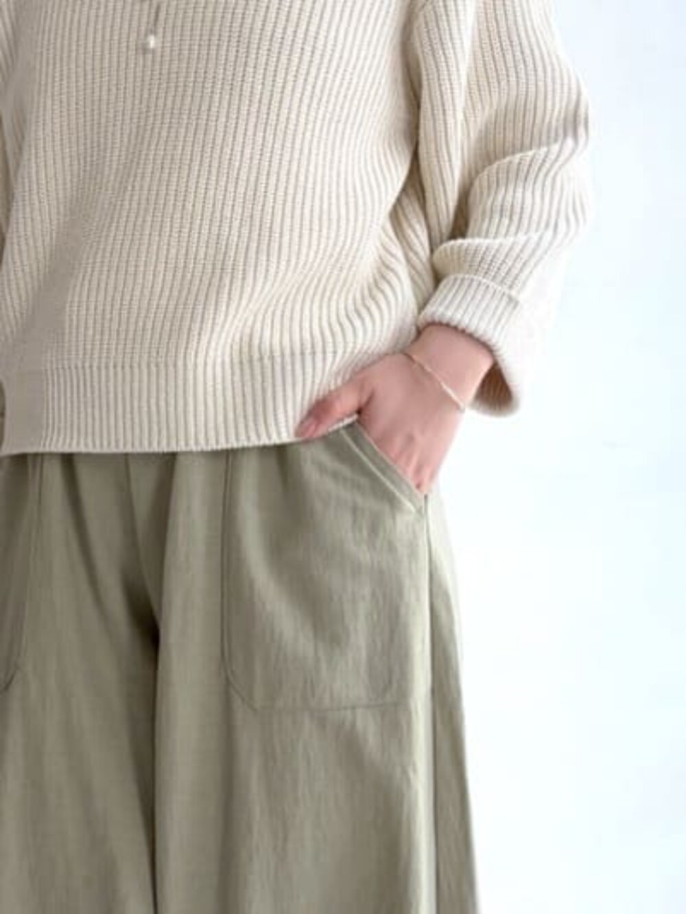 ホワイト系のニット/セーター、グリーン系のその他パンツ、ブラック系のトートバッグを着用したレディースの冬コーディネートの4枚目の写真