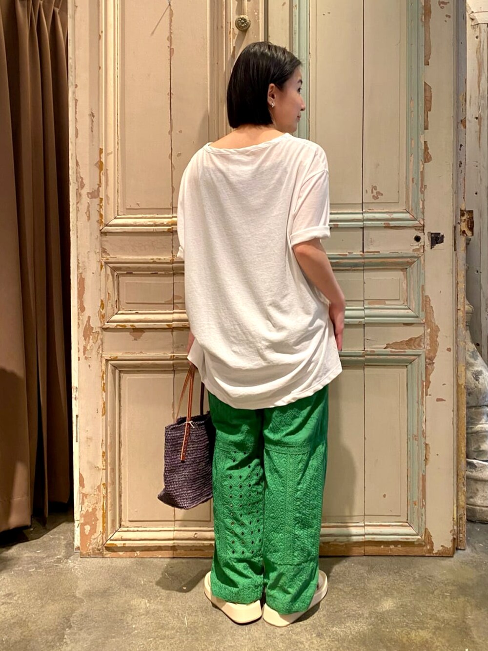 ホワイト系のTシャツ/カットソー、グリーン系のその他パンツ、ブラック系のかごバッグを着用したレディースの春コーディネートの3枚目の写真