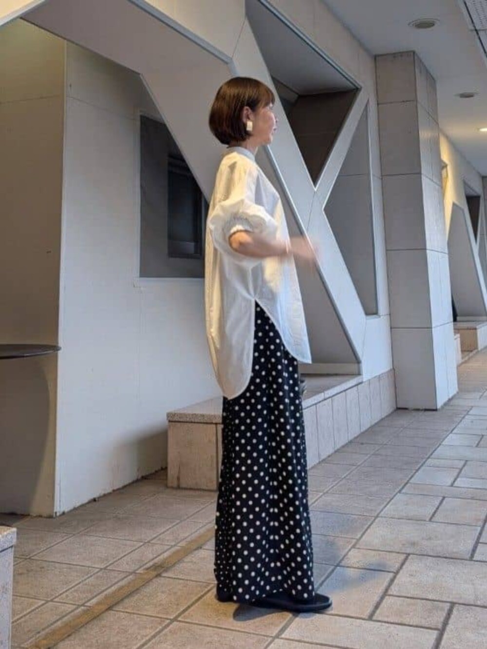 ブラック系のパンプス、ホワイト系のシャツ/ブラウスを着用したレディースの冬コーディネートの6枚目の写真