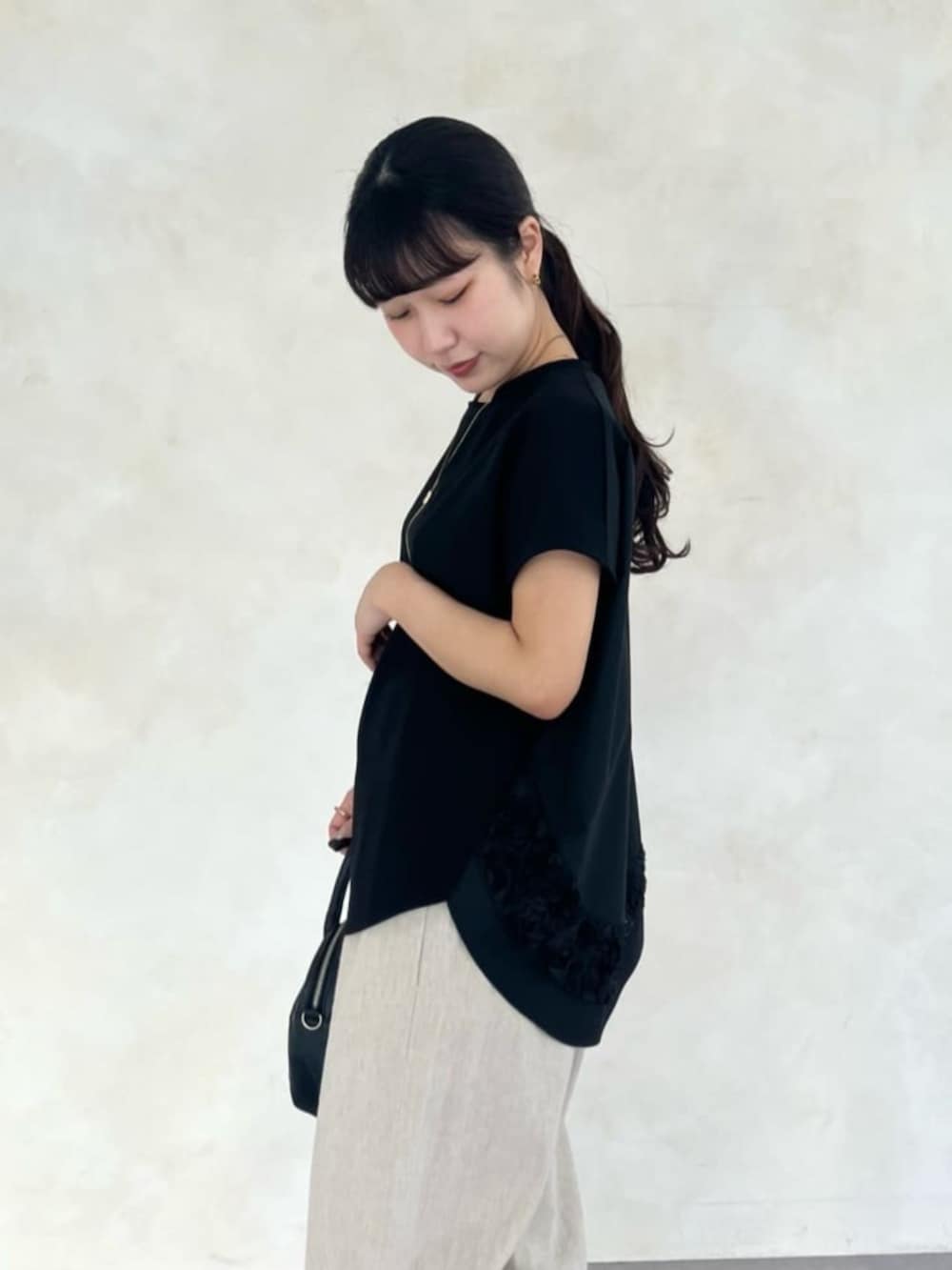 ベージュ系のその他パンツ、ブラック系のTシャツ/カットソー、ブラック系のサンダルを着用したレディースの春コーディネートの8枚目の写真