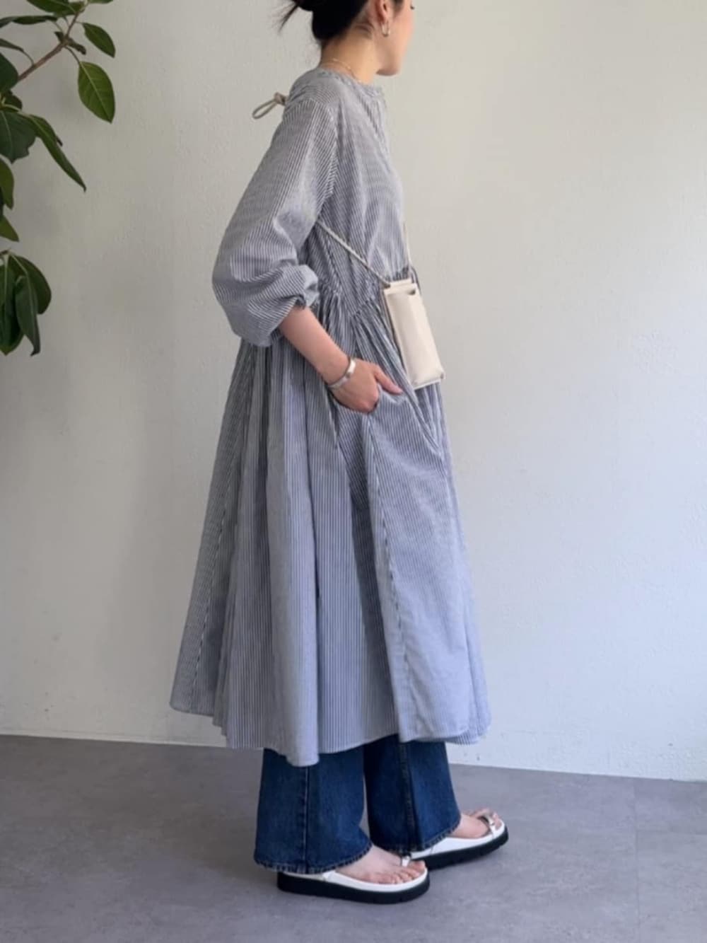 ホワイト系のショルダーバッグ、ブルー系のワンピースを着用したレディースの冬コーディネートの2枚目の写真