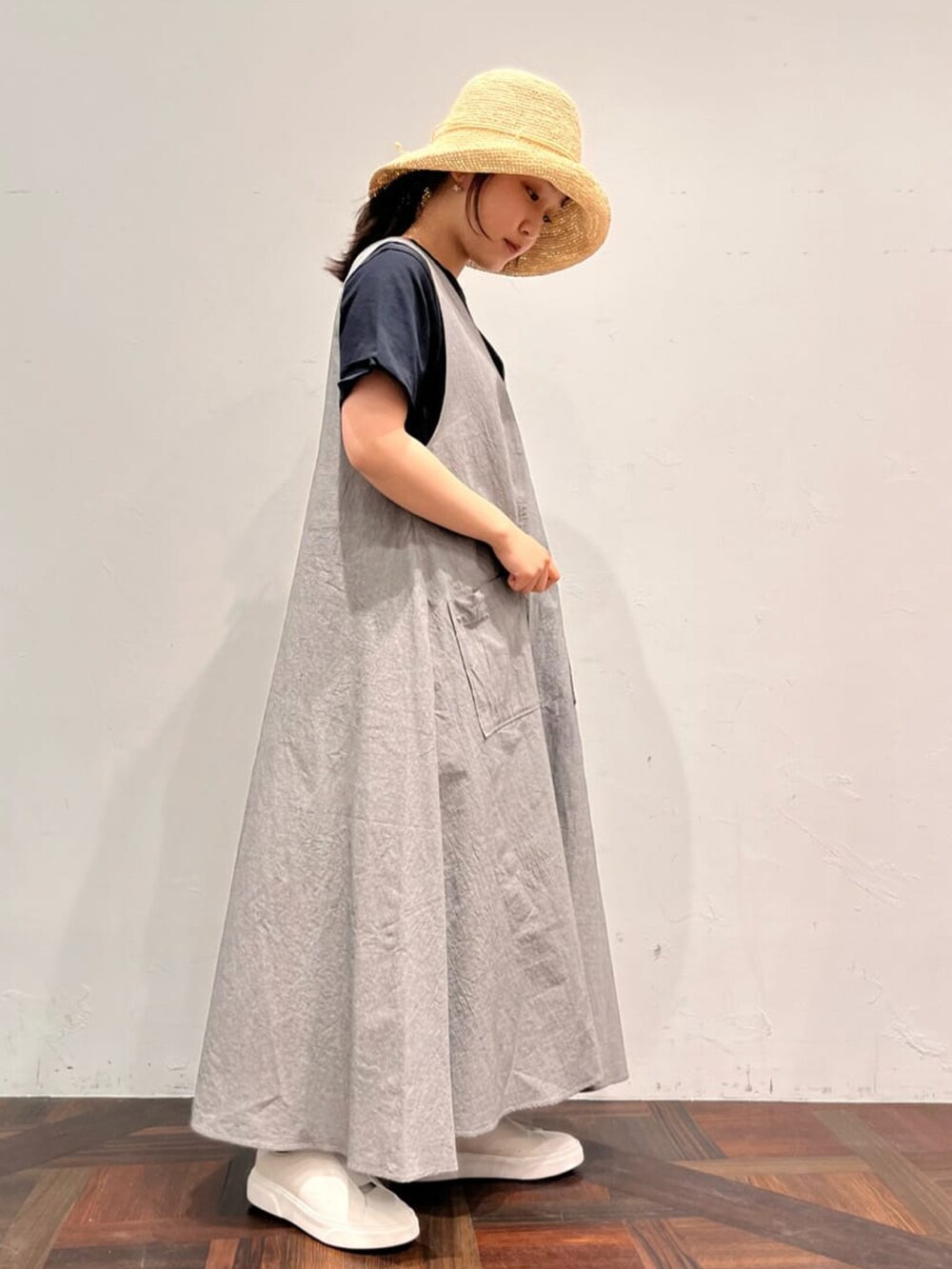 グレー系のワンピース、ブラック系のTシャツ/カットソー、ホワイト系のトートバッグを着用したレディースの春コーディネートの2枚目の写真