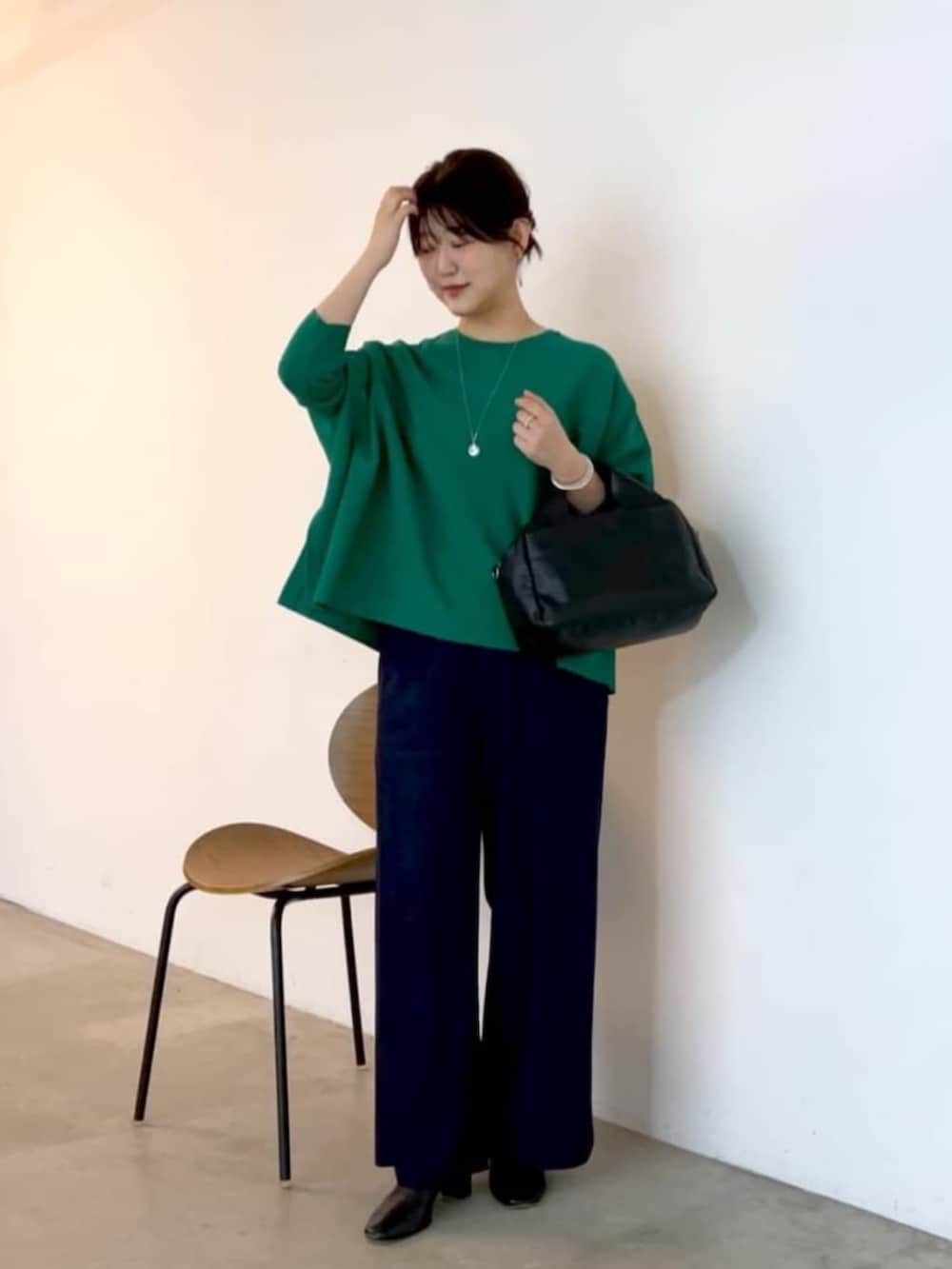 ブルー系のその他パンツ、ブラック系のボストンバッグ、グリーン系のニット/セーターを着用したレディースの夏コーディネートの2枚目の写真