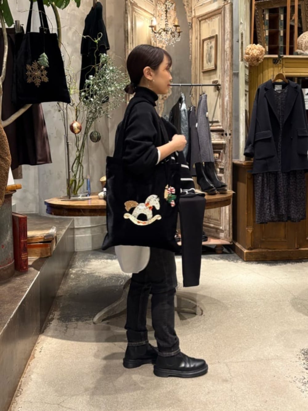 ブラック系のニット/セーター、ブラック系のデニムパンツ、ホワイト系のシャツ/ブラウスを着用したレディースの冬コーディネートの7枚目の写真