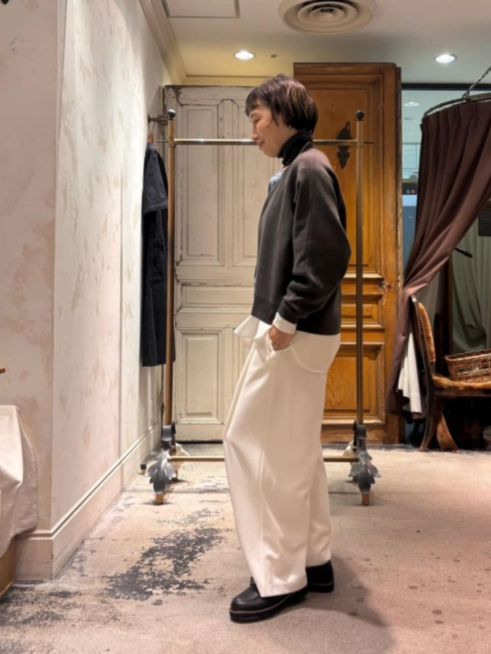 グレー系のニット/セーター、ブラック系のトートバッグ、ホワイト系のその他パンツを着用したレディースの秋コーディネートの6枚目の写真