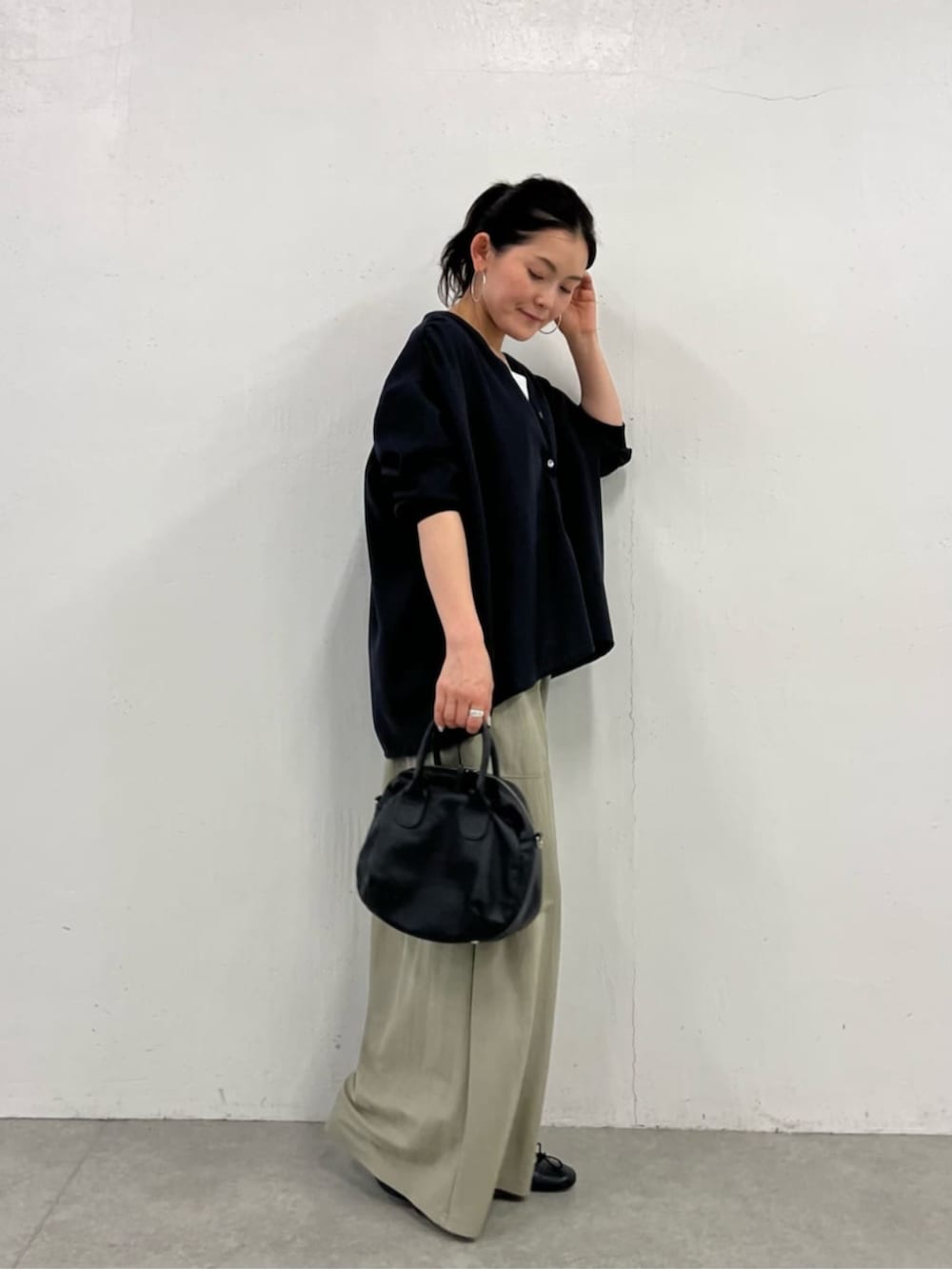 ブラック系のボストンバッグ、グリーン系のその他パンツ、ブルー系のシャツ/ブラウスを着用したレディースの冬コーディネートの2枚目の写真